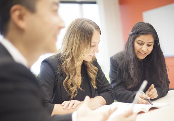 Two female and one male student sitting together and studying