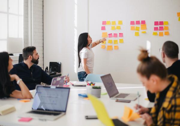 A team of people working in a room with sticky notes on the wall