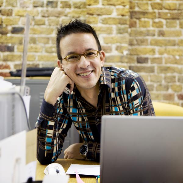 A student using a laptop and posing for a picture