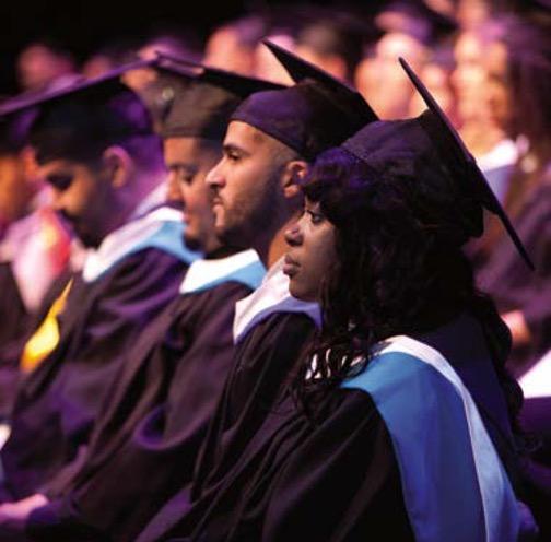 Grads wearing regalia at a ceremonuy